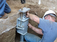 Foundation repair contractors installing the foundation bracket in Douglas.