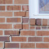 long jagged cracks starting at the corner of a window along a brick wall on a Arizona City home